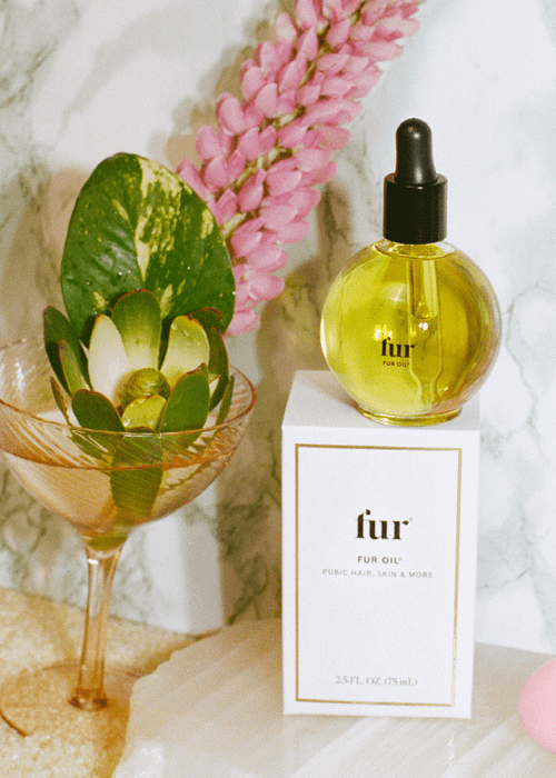 Bottle of Fur Oil placed on a box next to other accessories
