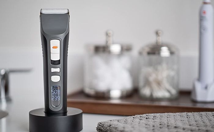 A black electric trimmer placed on its charging stand