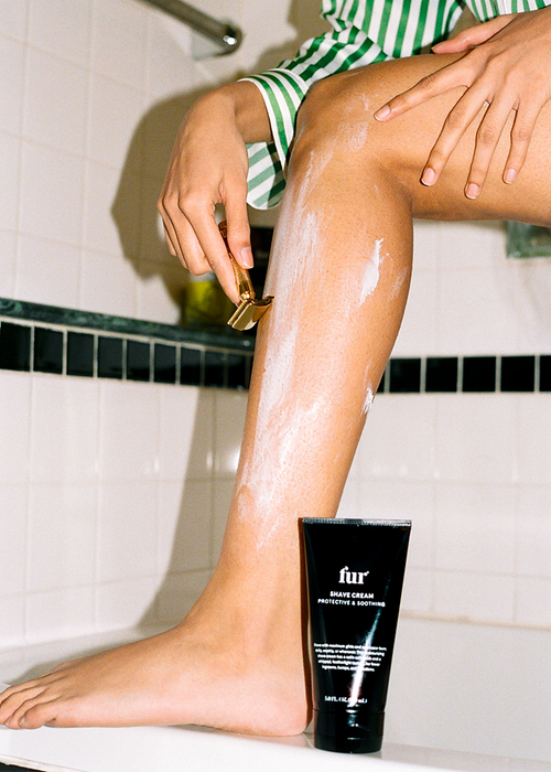 Model applying shave cream on legs