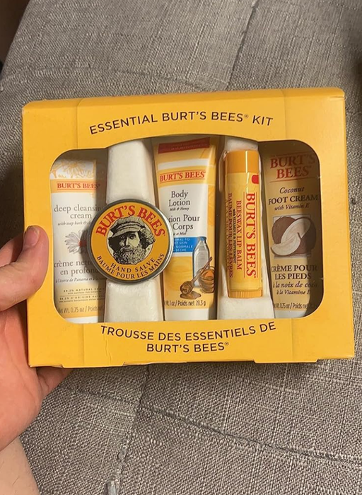 Burt's Bees essentials kit, featuring face wash, body lotion, foot cream, lip balm, and hand salve, all packaged in yellow containers.
