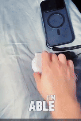 A hand holding a device next to a phone case and headphones, with text that reads