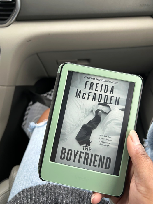 A person holding an e-reader displaying the book cover for.