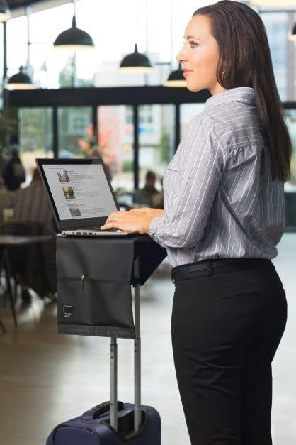 A model balancing a laptop on a black square tray attached to the top of their suitcase handle.