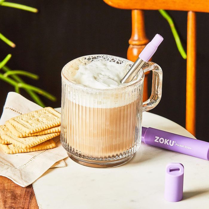 The straw fully extended and resting inside a coffee cup, ready for use.