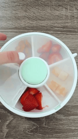 A reviewer spins the snack container, revealing snacks in each of its compartments.