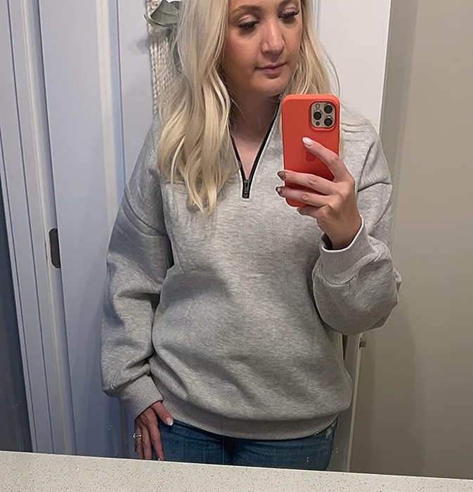 A reviewer wearing the gray version of the pullover sweatshirt.
