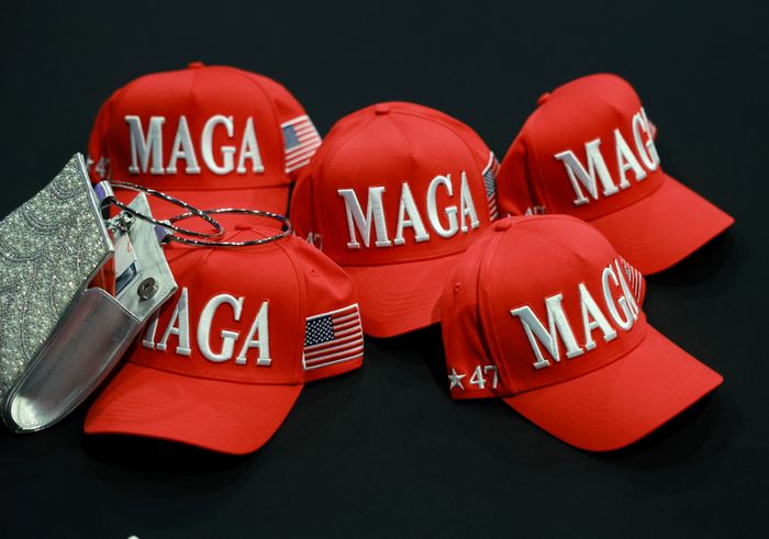 Five red MAGA hats featuring American flag patches and the number "47" are arranged together, accompanied by a sparkling decorative item
