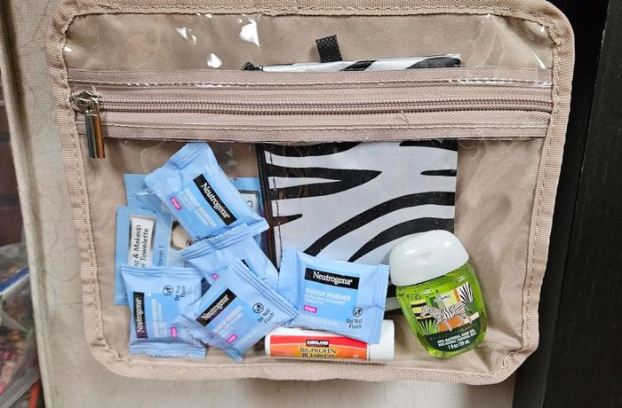 A reviewer photo with several packs of makeup remover wipes neatly stored in their toiletry bag.