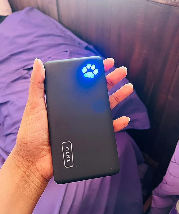 A reviewer holding the small, portable charger.