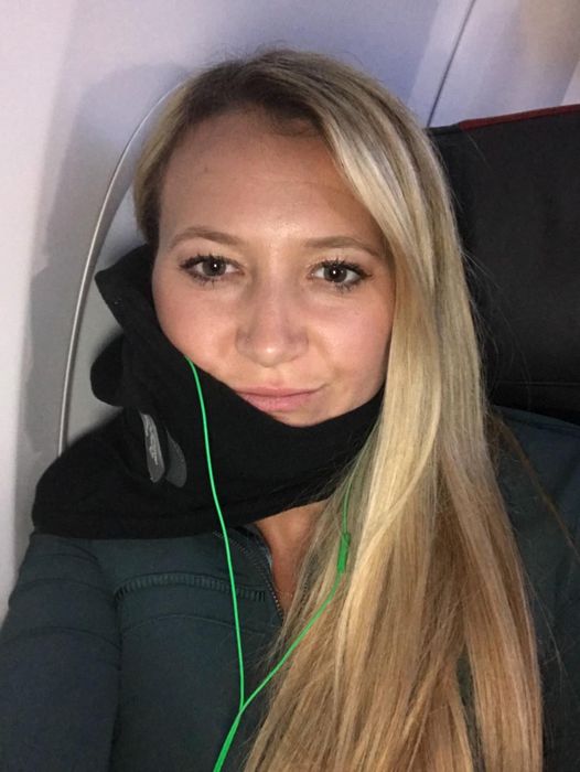 Another reviewer wearing the black Trtl neck pillow while flying.