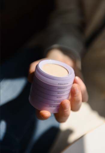 A hand holding a purple beauty stack.