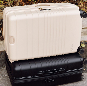A stack of the Béis white and black 29-inch suitcases, one on top of the other.