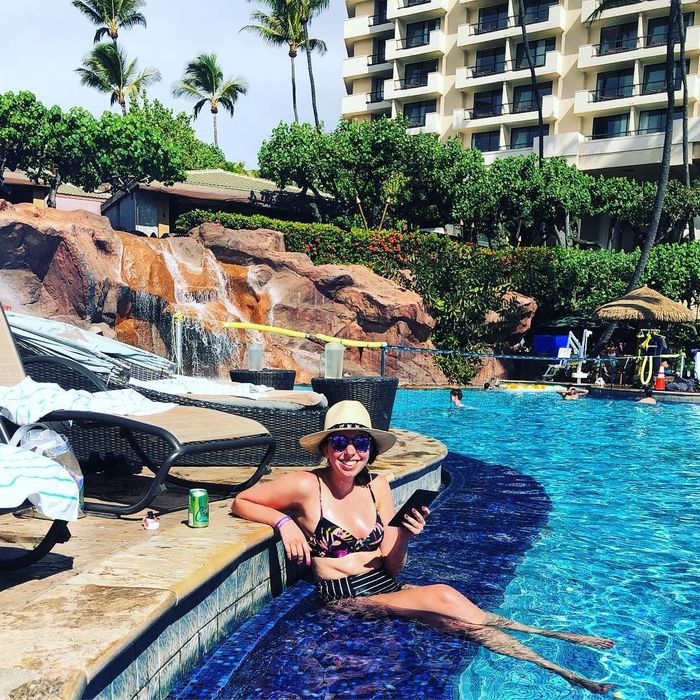 The author lounging by the pool, Kindle in hand, proving the ultimate vacation companion.