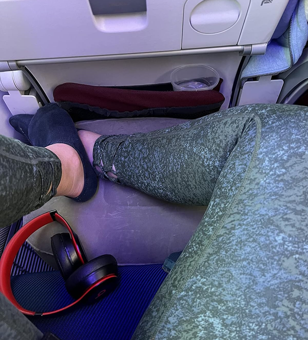 A reviewer enjoying the inflatable footrest during their flight.