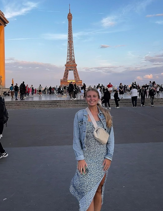 A reviewer rocking the white belt bag in front of the Eiffel Tower.