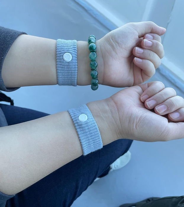 A reviewer showcasing the Sea Bands worn on both wrists.