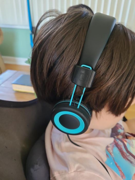 A child wearing a pair of black and blue headphones.