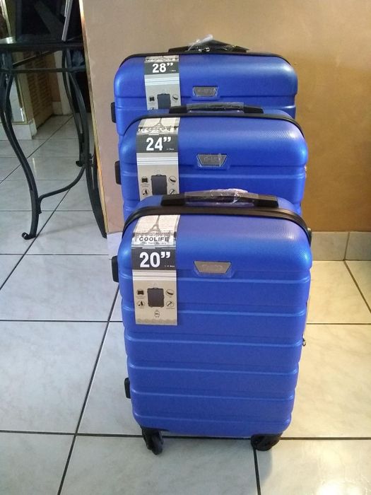 A photo of the same luggage set in dark blue, displayed in the reviewer's home.