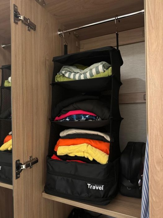 A packing cube hanging in a closet, demonstrating its organizational benefits.
