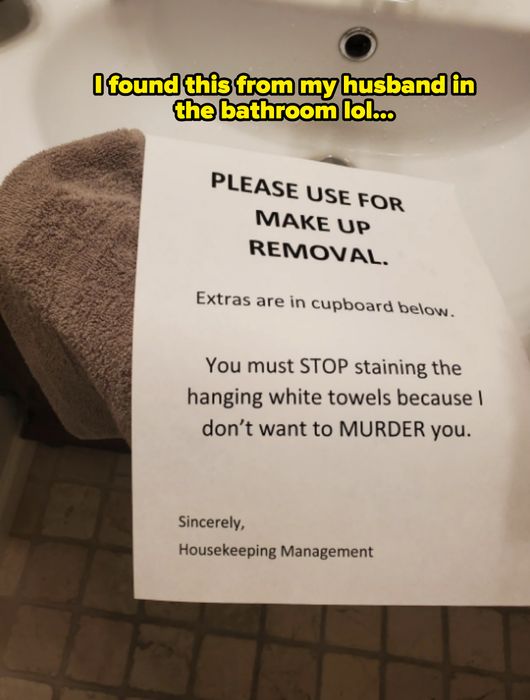 A note on a towel humorously warns against makeup stains, threatening to “MURDER” anyone who disobeys, with extras available in the cupboard below.