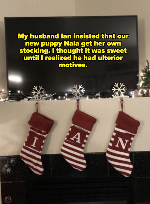 Three red-and-white striped Christmas stockings hanging beneath a TV, each labeled with a single letter to spell 'IAN.' Snowflakes decorate the mantel