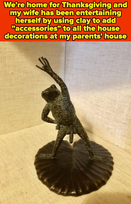 A frog sculpture positioned on a leaf with one arm raised and the other resting on its hip, displayed against a textured background