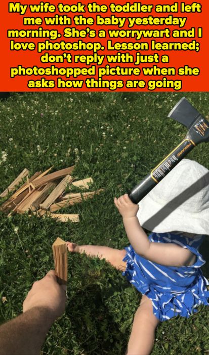 A baby dressed in stripes cheerfully holds a toy axe while sitting on grass next to a stack of wood