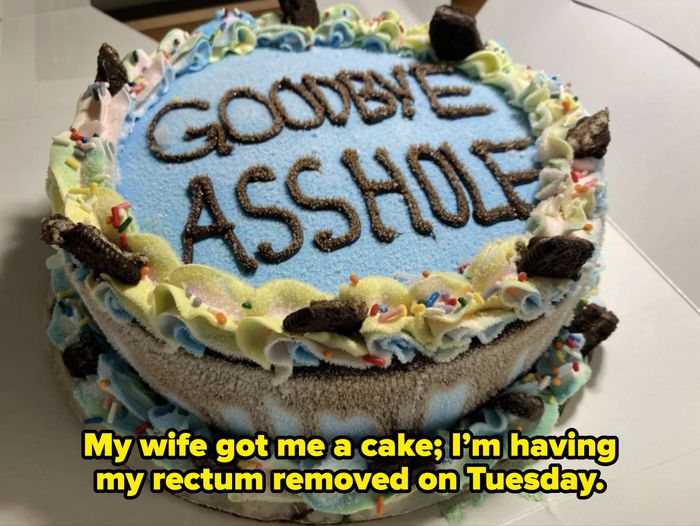 A cake with the message 'GOODBYE ASSHOLE' written in frosting, adorned with icing swirls and cookies around the edges