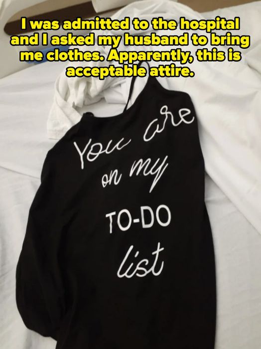 A black shirt reading 'You are on my TO-DO list' resting on a bed beside white sheets