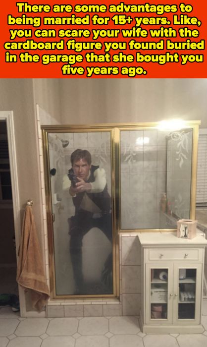 A person striking a pose in front of a bathroom mirror, holding a camera. The text mentions a cardboard figure from five years ago.