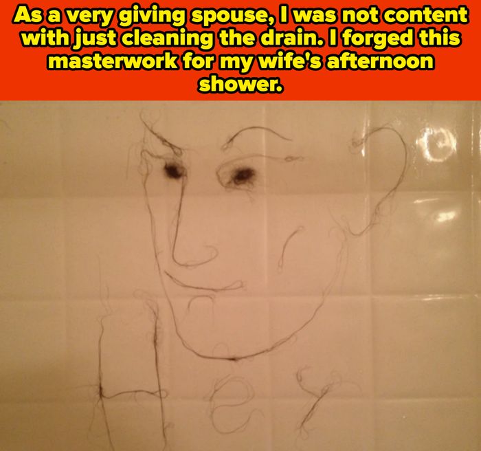 A simple line drawing of a face on a tiled wall, possibly created with hair