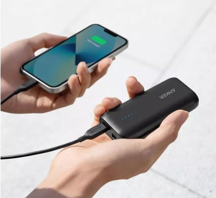 Portable power bank charging a smartphone outdoors