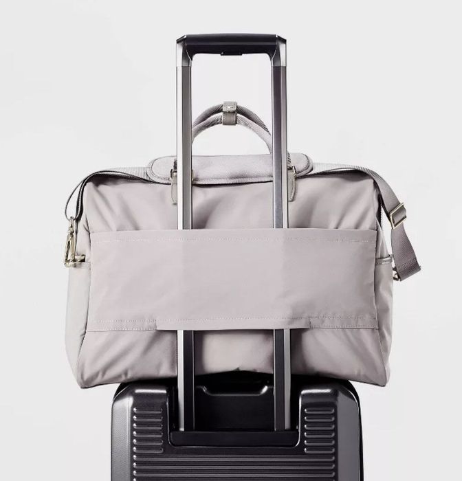 A weekender bag resting on a suitcase