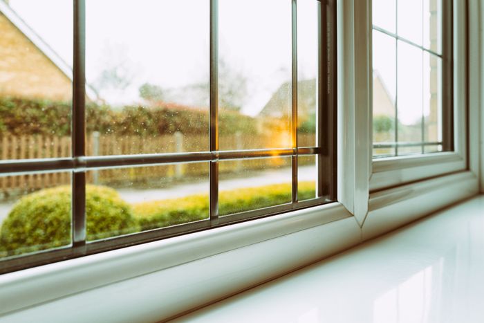 A clear window framing a softly blurred view of a lush green landscape outside