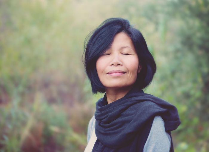 Woman with a calm expression wearing a scarf outdoors