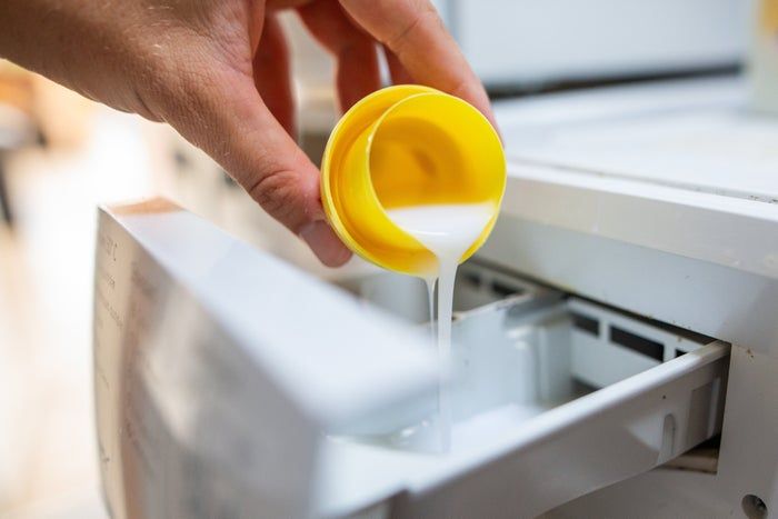 Pouring liquid detergent into the washing machine dispenser