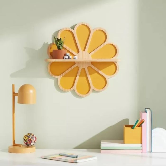 A flower-shaped shelf mounted on the wall, displaying decorative items and books beside a soft lamp.