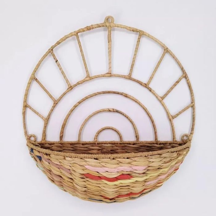 A woven half-circle wall basket featuring a natural and rainbow color pattern, ideal for stylish storage or decor.