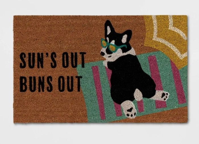 Illustrative door mat featuring a cartoon corgi wearing sunglasses, lounging on a beach towel with the text