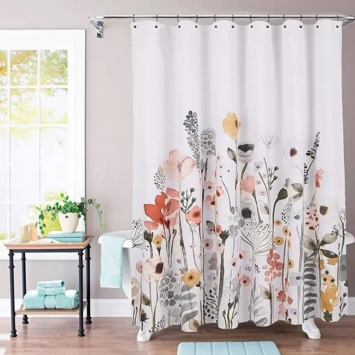 light-colored shower curtain with a delicate floral design hanging in a bathroom