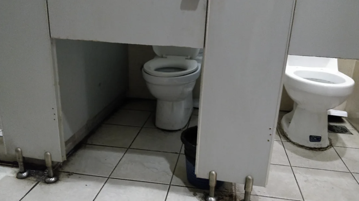 Public restroom with two toilet stalls, but the doors don’t cover the toilet area