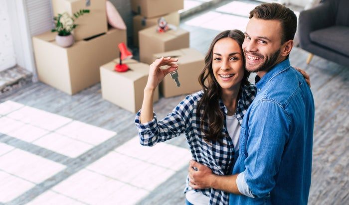 A couple proudly holding the keys to their newly purchased home.