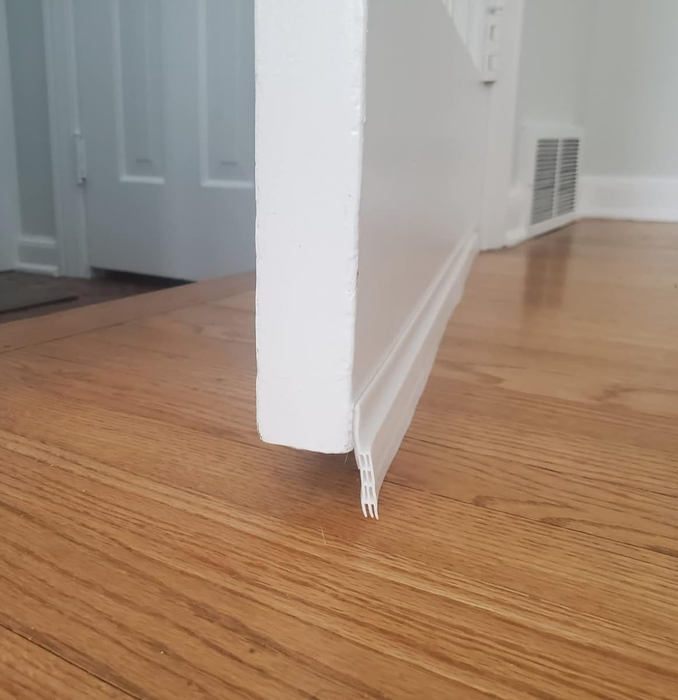 The door is open, showcasing the draft stopper covering the gap underneath