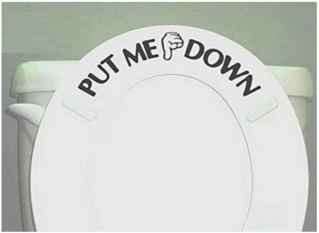 A toilet with the seat up, featuring a decal that reads, 'put me down.'