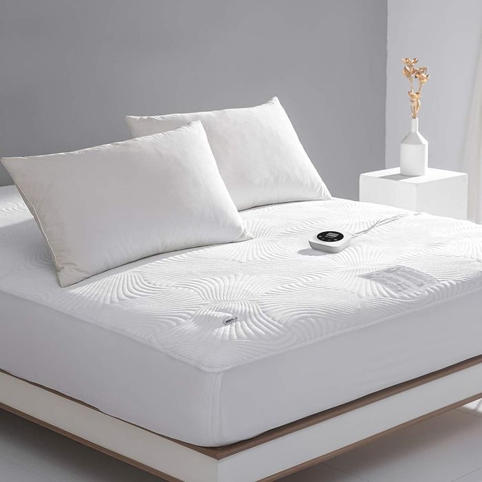 A queen-sized bed with the heated mattress pad and dual controllers in place