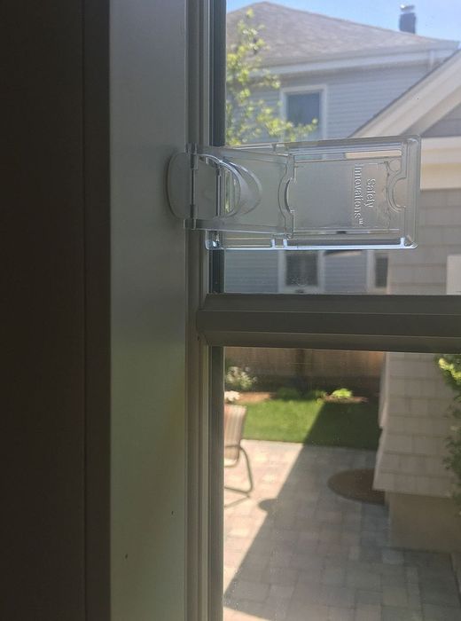 A window with a clear lock placed on the side molding, effectively preventing it from opening fully