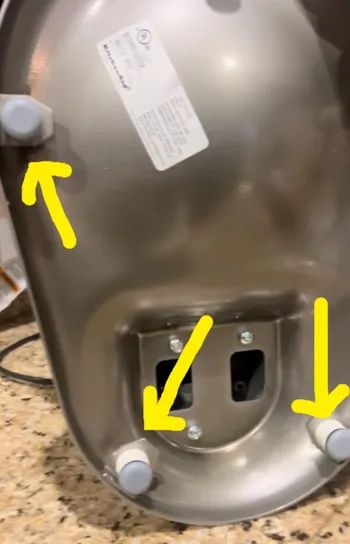 The underside of a kitchen mixer, with sliders attached to its base.