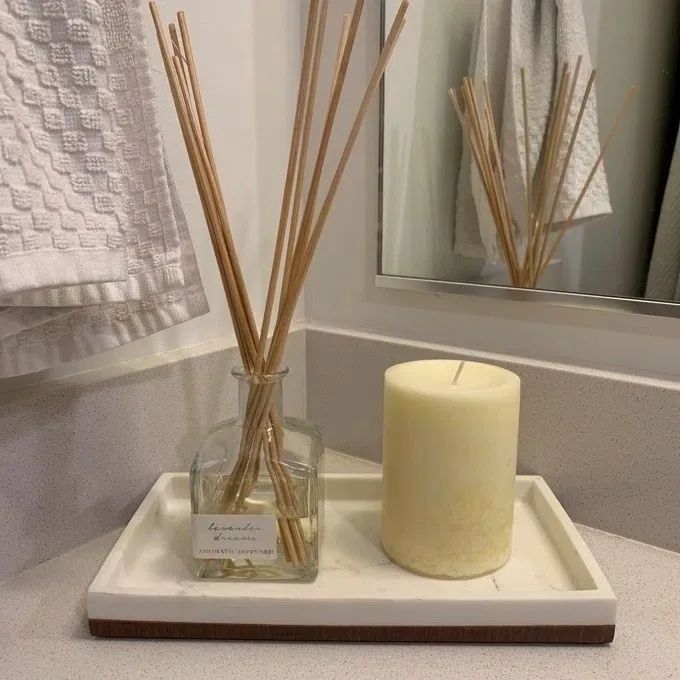 A sleek diffuser elegantly placed on a bathroom counter, with multiple reeds gently dispersing a soothing lavender aroma.