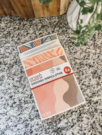 A pack of Eparé Swedish Dishcloths, a 4-pack featuring geometric and abstract patterns, neatly arranged on a kitchen countertop.