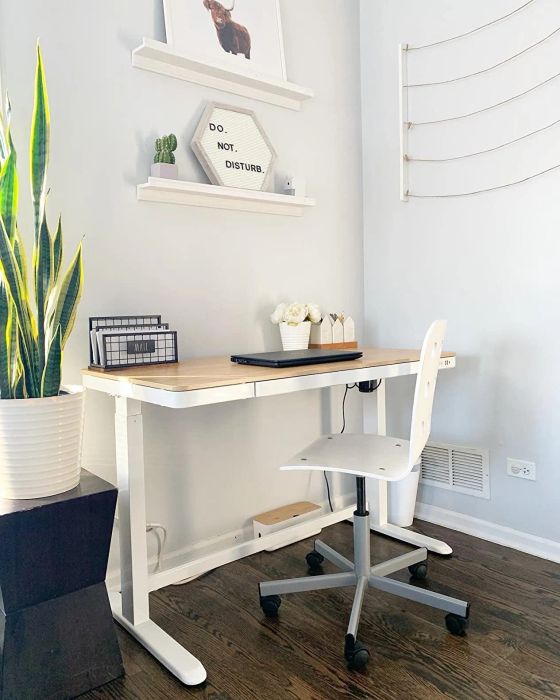 A reviewer's desk features a sleek white frame paired with a bamboo top.